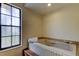 Relaxing bathroom featuring a tiled tub, soft natural light, and a convenient step for easy access at 107 Garland Cir, Palm Harbor, FL 34683