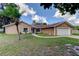 Inviting single-story home with a well-maintained lawn and an attached two-car garage at 107 Garland Cir, Palm Harbor, FL 34683