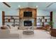 Spacious living room featuring a stone fireplace, built-in shelving, and comfortable seating at 107 Garland Cir, Palm Harbor, FL 34683