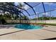 A screened pool surrounded by a green lawn is perfect for outdoor enjoyment at 107 Garland Cir, Palm Harbor, FL 34683