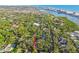 Aerial view of a two story home surrounded by mature trees and waterway in distance at 11209 Spring St, Largo, FL 33774
