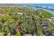 Aerial view of a two story home surrounded by mature trees and waterway in distance at 11209 Spring St, Largo, FL 33774