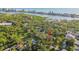 Aerial view of a two story home surrounded by mature trees and waterway in distance at 11209 Spring St, Largo, FL 33774