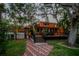 A charming two-story home with a brick patio leading to a raised deck and lush, mature landscaping at 11209 Spring St, Largo, FL 33774