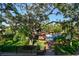 Overhead view of backyard with a pool, covered pavilion, green lawn, and mature trees at 11209 Spring St, Largo, FL 33774