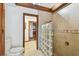 Bathroom with a glass-block shower, toilet, and doorway leading to the rest of the house at 11209 Spring St, Largo, FL 33774