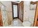 Bathroom featuring a glass-block window, toilet, and wooden door to the shower at 11209 Spring St, Largo, FL 33774