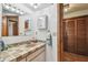 Bathroom vanity with stone-tile countertop, sink, mirror, and wooden door to closet at 11209 Spring St, Largo, FL 33774