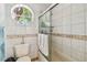 Cozy bathroom with mosaic tile accents on the vanity and shower, complemented by natural light from a porthole window at 11209 Spring St, Largo, FL 33774