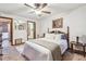 Comfortable bedroom featuring a wood frame bed, ceiling fan, carpeted floors, and natural lighting through windows at 11209 Spring St, Largo, FL 33774
