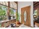 Bright entryway featuring a decorative glass door, wooden accent table, and tiled floor at 11209 Spring St, Largo, FL 33774