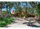 Two story home with a beautiful front yard, mature trees, and a covered carport at 11209 Spring St, Largo, FL 33774