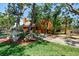 Two story home with a beautiful front yard, mature trees, and a covered carport at 11209 Spring St, Largo, FL 33774