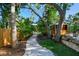 Gravel pathway leading through lush landscaping to the main house; mature trees providing cooling shade at 11209 Spring St, Largo, FL 33774