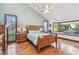 Bright main bedroom featuring a wooden bed frame, hardwood floors, and natural light from multiple windows at 11209 Spring St, Largo, FL 33774