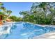 Sparkling in-ground pool surrounded by lush greenery and a stone patio, perfect for relaxation and entertainment at 11209 Spring St, Largo, FL 33774