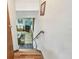 Stairway leading down to the living area with wood floors and a handrail at 11209 Spring St, Largo, FL 33774