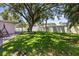 Expansive backyard featuring lush green grass and mature trees, creating a serene outdoor space at 1140 Mcfarland St, Dunedin, FL 34698