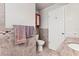 Neutral bathroom featuring tiled walls, a toilet, and a storage cabinet at 1140 Mcfarland St, Dunedin, FL 34698