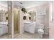Bright bathroom featuring a walk-in shower, white vanity, and neutral tile flooring at 1140 Mcfarland St, Dunedin, FL 34698