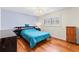 Cozy bedroom featuring wood floors, a blue bedspread, and a window with shutters at 1140 Mcfarland St, Dunedin, FL 34698