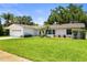 Well-maintained single-story home with a lush green lawn and lovely landscaping at 1140 Mcfarland St, Dunedin, FL 34698