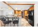 Kitchen boasts wooden cabinets, black appliances, and pendant lighting above bar at 1140 Mcfarland St, Dunedin, FL 34698
