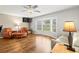 Bright living room features hardwood floors, a ceiling fan, and ample natural light at 1140 Mcfarland St, Dunedin, FL 34698