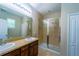 Bathroom featuring double sinks, granite counters, and a glass-enclosed tiled shower at 11252 Merganser Way, New Port Richey, FL 34654