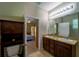 Bright bathroom with double sinks, granite counters, and a view into the main bedroom at 11252 Merganser Way, New Port Richey, FL 34654