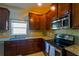 Eat-in kitchen featuring granite countertops, stainless appliances, and dark wood cabinetry at 11438 Merganser Way, New Port Richey, FL 34654