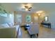 Bright living room with neutral walls, tiled flooring, and comfortable seating beneath a modern ceiling fan at 11252 Merganser Way, New Port Richey, FL 34654