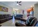 Open-concept living room features tile floors and dark leather sofas, perfect for relaxing and entertaining at 11252 Merganser Way, New Port Richey, FL 34654