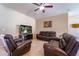 Cozy living area featuring plush leather seating, a TV, and a ceiling fan for a relaxed atmosphere at 11252 Merganser Way, New Port Richey, FL 34654