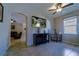Open-concept living room with a ceiling fan and a television; warm tile flooring adds to the charm at 11252 Merganser Way, New Port Richey, FL 34654