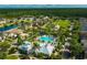 Aerial view showcasing community amenities: pool, park, and green spaces nestled among attractive homes and a serene pond at 12327 Eagle Swoop Pl, Riverview, FL 33579