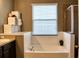 Bright bathroom featuring a soaking tub with tile surround and a window for natural light at 12327 Eagle Swoop Pl, Riverview, FL 33579