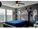 Cozy bedroom with modern ceiling fan, natural light, and decorated with baseball memorabilia at 12327 Eagle Swoop Pl, Riverview, FL 33579