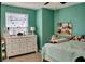 Comfortable bedroom with a well lit white dresser, ample natural light, and soft colors for a peaceful retreat at 12327 Eagle Swoop Pl, Riverview, FL 33579
