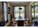 Bright dining room with a modern table, chairs, and a large window overlooking the backyard at 12327 Eagle Swoop Pl, Riverview, FL 33579