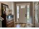 Bright foyer featuring hardwood floors, stylish decor, and sidelight windows around the front door at 12327 Eagle Swoop Pl, Riverview, FL 33579