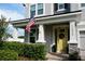 Inviting home exterior with a yellow front door, manicured landscaping and an American flag at 12327 Eagle Swoop Pl, Riverview, FL 33579