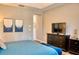 Comfortable main bedroom with a large bed, dark wood furniture, and a calm color palette at 12327 Eagle Swoop Pl, Riverview, FL 33579