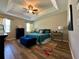Spacious main bedroom with tray ceiling, hardwood floors, and tasteful decor at 12327 Eagle Swoop Pl, Riverview, FL 33579