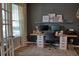 Well-lit home office with dark walls, dual monitors, and a comfortable work space at 12327 Eagle Swoop Pl, Riverview, FL 33579