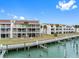 Beautiful condo complex from the waterway featuring outdoor balconies, chimneys, and well-kept landscaping at 12360 Capri N Cir # 106, Treasure Island, FL 33706