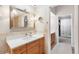 Bathroom featuring a granite countertop, wood cabinetry, modern fixtures, and adjacent closet at 12360 Capri N Cir # 106, Treasure Island, FL 33706