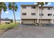 View of condo complex featuring attached garages, neutral colors, and well-maintained grounds at 12360 Capri N Cir # 106, Treasure Island, FL 33706