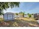 Large backyard with a shed, young palms, and a white fence, offering plenty of space for outdoor activities at 12595 95Th N St, Largo, FL 33773