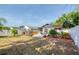 Spacious backyard featuring a stone patio, lush green grass, a hot tub, and a white picket fence at 12595 95Th N St, Largo, FL 33773